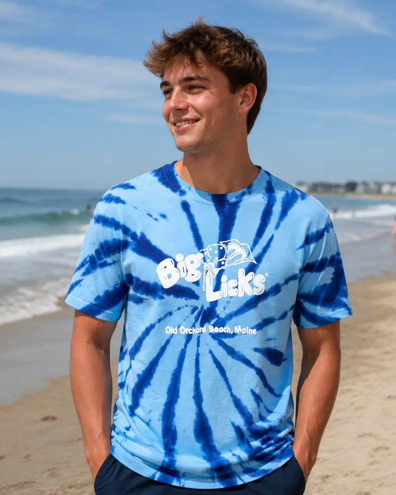A man wearing the blue tie-dye Big Licks t-shirt on the beach